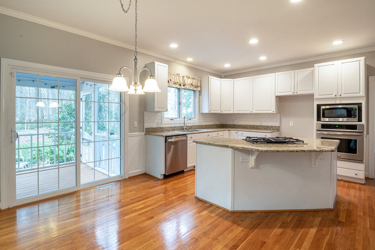 Bright modern kitchen featuring marble island and wooden flooring, ideal for family spaces.